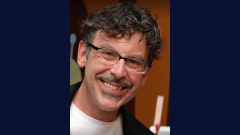 A person with curly hair wearing glasses