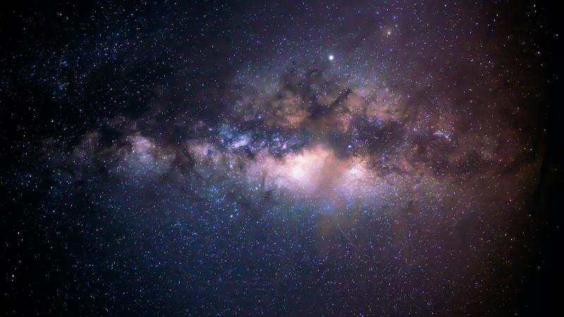 The image is a photograph of the Milky Way galaxy, specifically showing the dense galactic core.