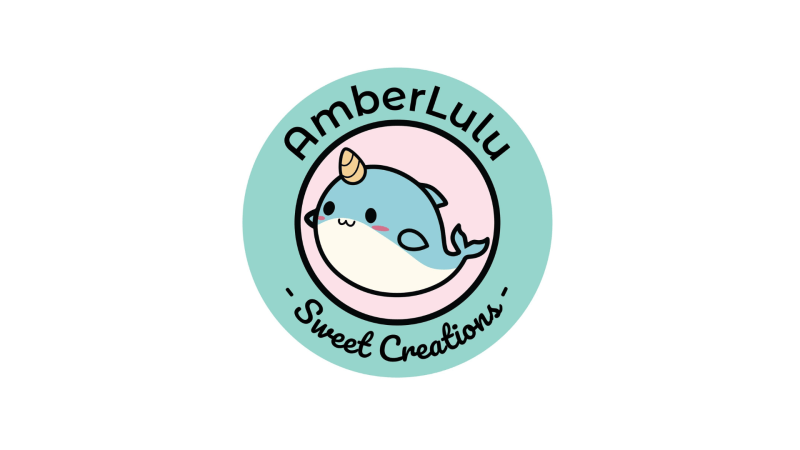 circular logo for “AmberLulu Sweet Creations” featuring a smiling blue narwhal inside pastel teal and pink rings