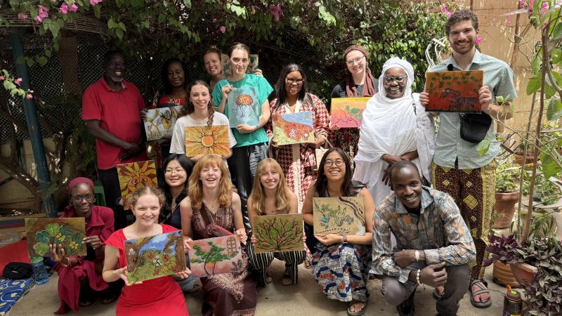 Students and staff show off their sous-verre paintings at Anta Germaine Gaye's studio