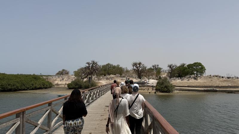 Students and staff crossing bridge to Fadiouth island.
