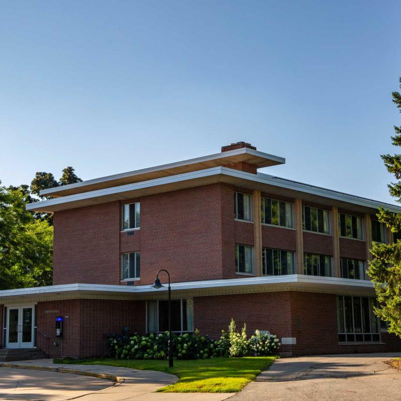 3-story tall red brick building with protruding flat roof 