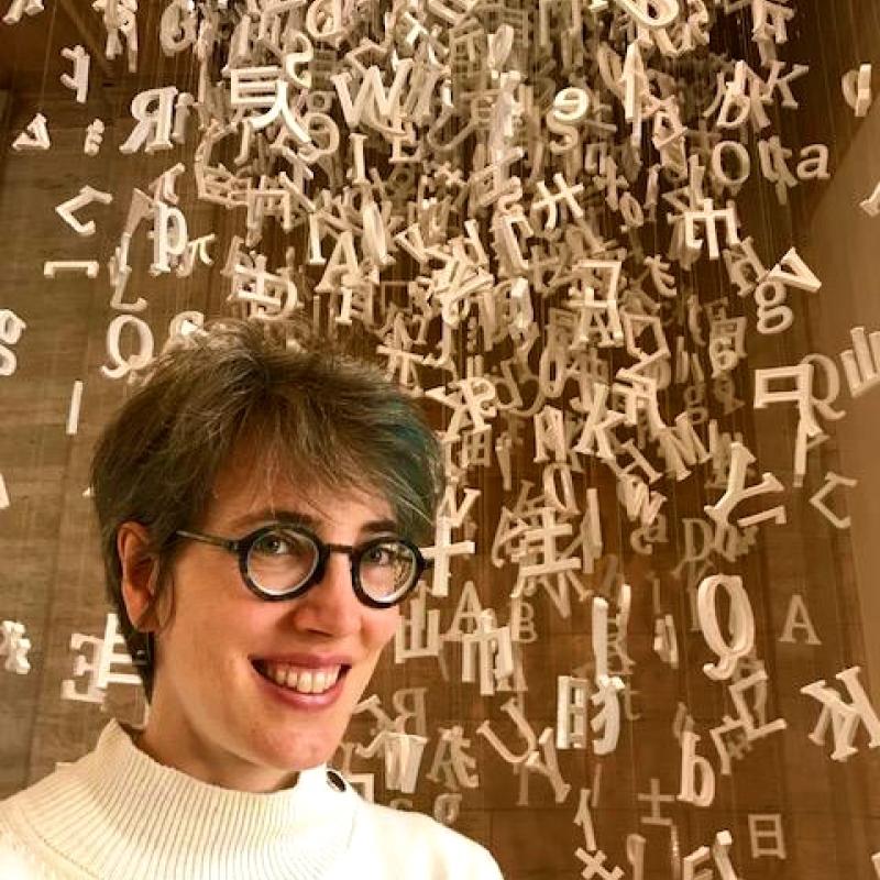 Brigid Vance smiling in front of sculpture at the Asian Art Museum in San Francisco, CA