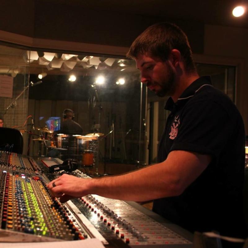 Audio engineer adjusting a recording console