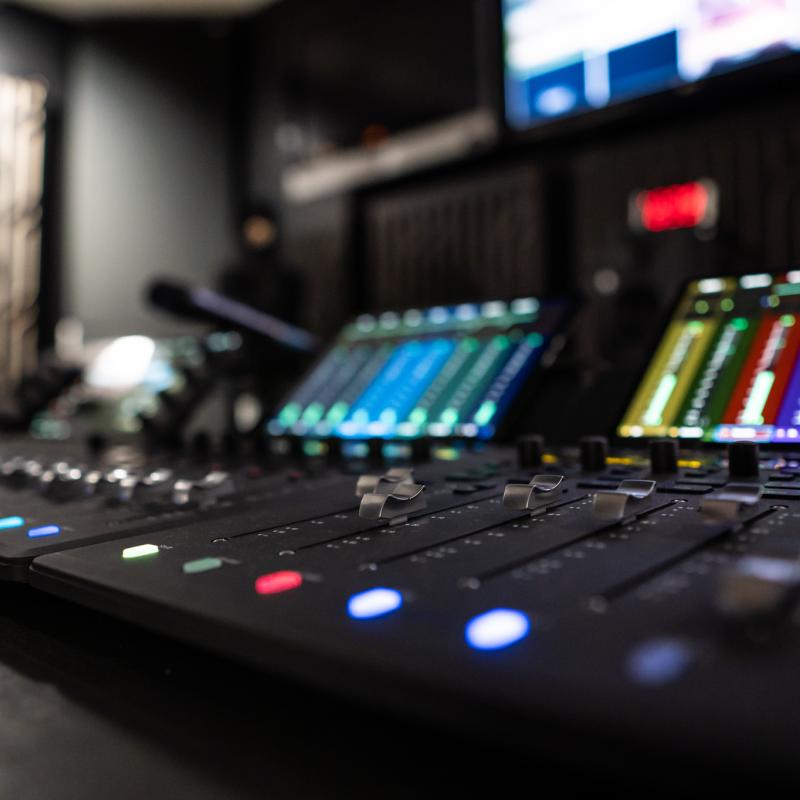 Audio console with multi-colored buttons and screens.