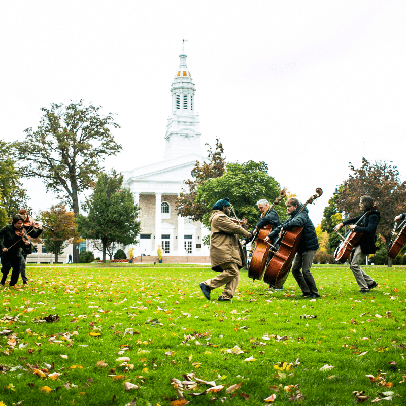 People play isntruments outside in front of Lawrence Chapel