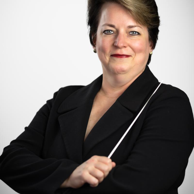 Kristin Roach holding a baton wearing a black jacket.