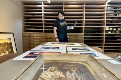 Val Muzzarelli peruses the selected works for their exhibit.