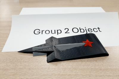 A small black square with a point at the end and a red star