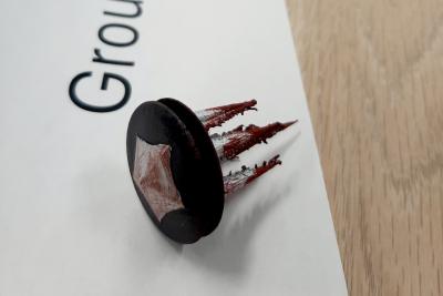 A small black circle with a grey star, four spikes extend from it
