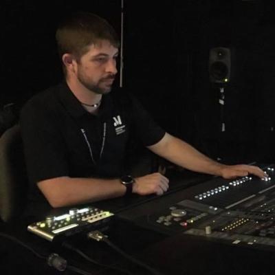 Audio engineer adjusting a recording console