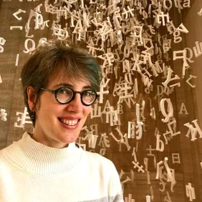 Brigid Vance smiling in front of sculpture at the Asian Art Museum in San Francisco, CA