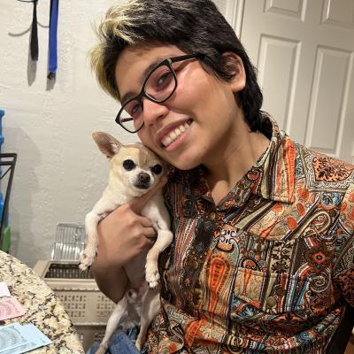 Headshot of Laurance Campos holding his dog.
