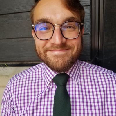 Photo of Mason wearing purple gingham shirt and green neck tie.