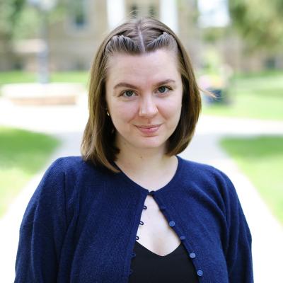 woman with short brown hair wearing a blue cardigan 