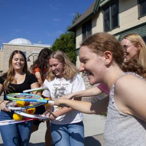 students with tennis rackets
