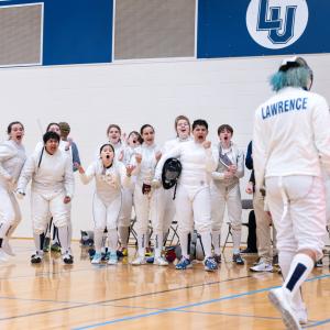 Members of the Lawrence fencing team react with joy at a win in the Wellness Center gym.