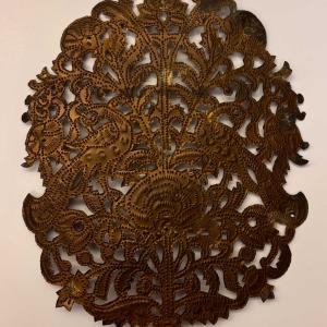 a metal stencil with organic designs against a white background. 
