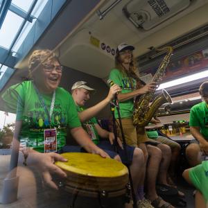 A small group of musicians playing instruments on a bus.