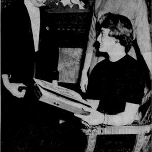 Three women examine a manuscript together