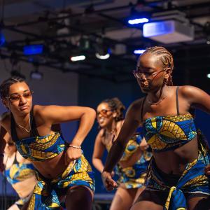 Students in brightly colored outfits dancing at Cultural Expressions.