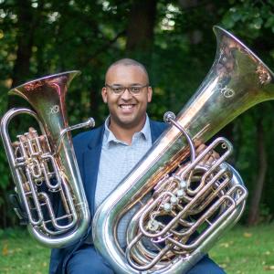 Zach Marley holding a tuba and euphonium.