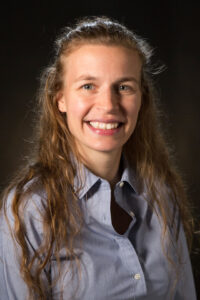 A woman with long hair smiling at the camera.