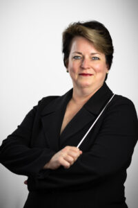 Kristin Roach holding a baton wearing a black jacket.